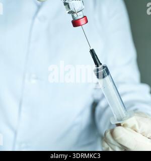 Medico preparando siringa con vaccino in laboratorio ospedaliero Foto Stock