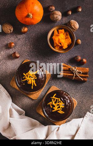 Dessert autunnale di zucca al cioccolato in bicchieri sul tavolo e vista verticale Foto Stock