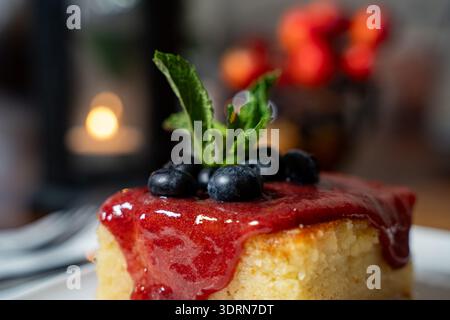 Primo piano della torta di semola con salsa di fragole e mirtilli. Foto Stock