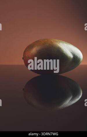 Mango maturo su sfondo in vetro scuro con riflesso Foto Stock