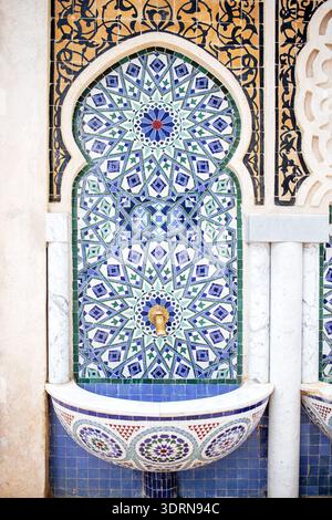 Fontana ornata caratterizzata da intricati lavori di piastrelle in colori vivaci, che mostrano motivi geometrici ed elementi di design tradizionali, Foto Stock