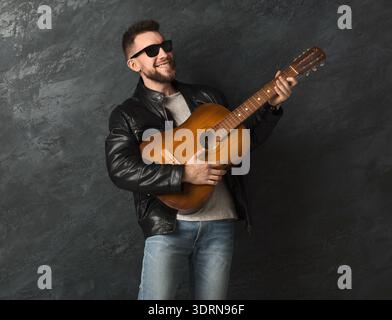 L'uomo suona la chitarra in ambiente Studio durante una sessione musicale con vibrazione informale e stile rilassato Foto Stock