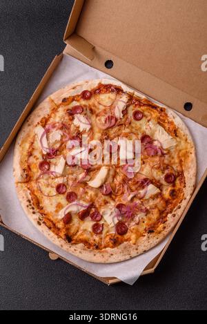 Pizza italiana con salsiccia, pollo e formaggio per cena. Pizza con salsiccia come sfondo alimentare per il tuo design Foto Stock