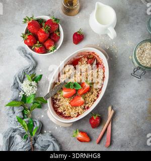 Torta sbriciolata di fragole e rabarbaro d'avena in teglia da forno Foto Stock