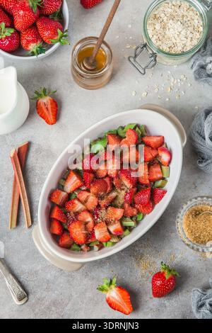 Preparazione di rabarbaro e fragola torta sbriciolata di avena Foto Stock