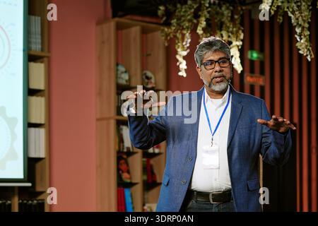Presentazione dell'uomo dell'Asia meridionale di mezza età in un ambiente moderno della Biblioteca Foto Stock