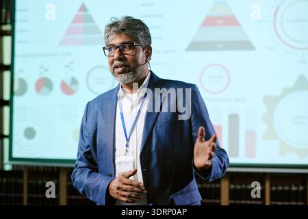 Presentazione di un uomo di mezza età davanti all'infografica aziendale Foto Stock