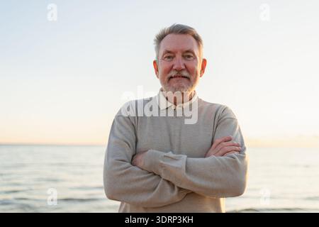 Ritratto all'aperto di un anziano europeo di mezza età, sicuro ed elegante, sulla spiaggia. Uomo maturo più anziano che sorride. Felice nonno anziano Foto Stock