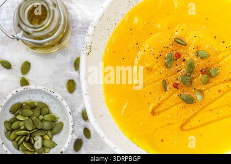 Zucca e purea di carota minestra con semi, pepe rosa e olio di oliva. Gustosa e salutare il pranzo per i buongustai Foto Stock