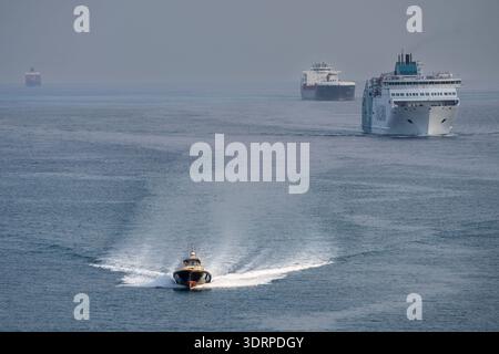 Pilota di porto che naviga di fronte alle navi che accedono al porto di Barcellona, ​​Catalonia, Spagna Foto Stock