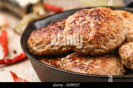 Cotolette di carne fritte fatte in casa (manzo, maiale, pollo, tacchino) con spezie e aglio in una padella di ghisa. Pranzo delizioso o di Foto Stock