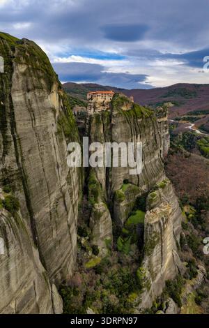 Meteora, Grecia. Fotografia aerea che cattura le monumentali colonne di arenaria e gli storici monasteri sulla cima della scogliera che si innalzano sopra la città di Kalambaka, S. Foto Stock