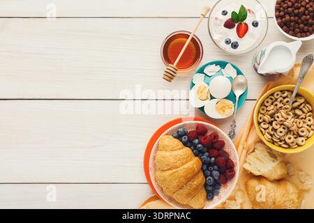 Colazione con vari cibi su un tavolo di legno chiaro al mattino Foto Stock