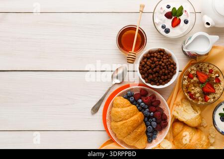 Collage di piatti della colazione con frutta, cereali e bevande disposti su un tavolo di legno Foto Stock