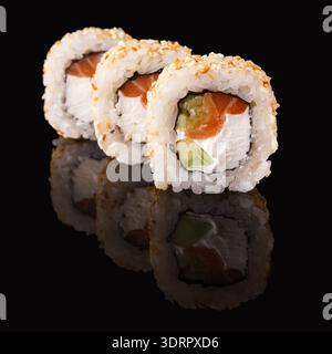 Collezione di sushi Rolls disposti in un motivo ordinato su una superficie nera Foto Stock