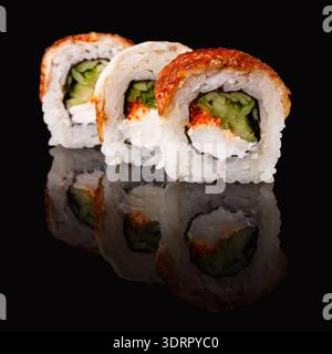 Sushi Rolls disposti su una superficie nera che mostra le loro forme e i loro colori Foto Stock