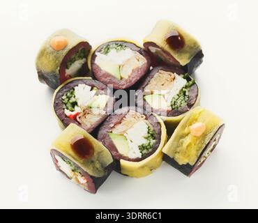 Collage di sushi Rolls disposti in un set creativo con varie ripieni su uno sfondo pulito Foto Stock