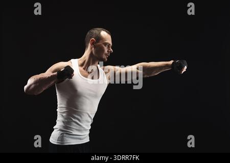 Collage di un uomo che pratica tecniche di pugilato in un ambiente buio che mostra la sua concentrazione e la sua forza Foto Stock