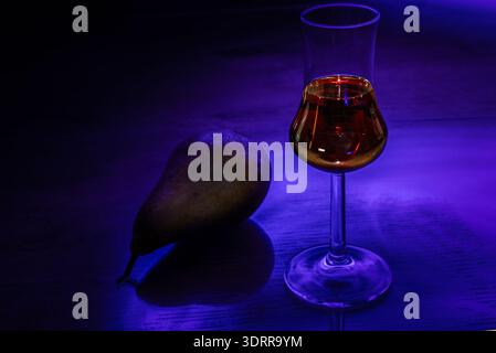 bicchiere di brandy alla pera con pere in azzurro Foto Stock