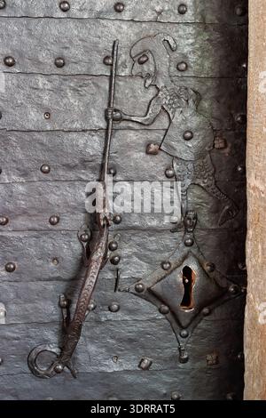 Porta di ferro medievale con un cavaliere che uccide un drago Foto Stock