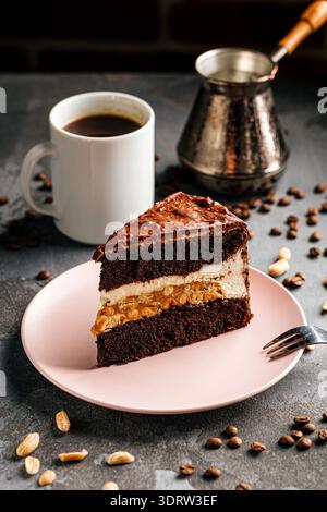 Fetta di torta al cioccolato con panna e arachidi Foto Stock