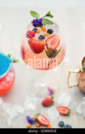 Bevanda colorata Collage con frutta fresca ed erbe su un tavolo di legno alla luce del giorno Foto Stock