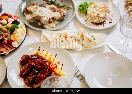 Elegante tavolo per banchetti con pasti gourmet, antipasti e ristorante festivo Foto Stock