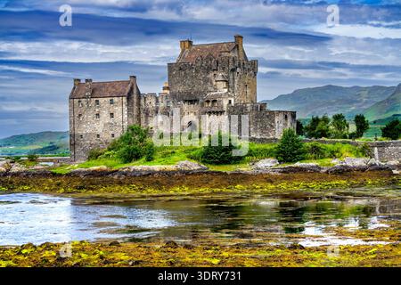 Il colorato castello di Eilean Donan kayak turisti Lochs Sea Lakes Highlands scozzesi Scozia. Castello costruito dal Clan Mackenzies nel 1200 Distrutto nel 1719 Foto Stock