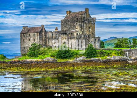 Il colorato castello di Eilean Donan kayak turisti Lochs Sea Lakes Highlands scozzesi Scozia. Castello costruito dal Clan Mackenzies nel 1200 Distrutto nel 1719 Foto Stock