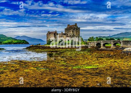 Il colorato castello di Eilean Donan kayak turisti Lochs Sea Lakes Highlands scozzesi Scozia. Castello costruito dal Clan Mackenzies nel 1200 Distrutto nel 1719 Foto Stock