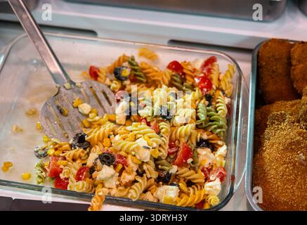 Insalata di pasta e pesto esposta nella sezione gastronomica del negozio locale Foto Stock
