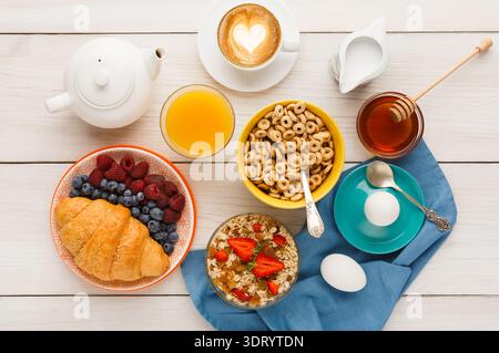 Colazione con vari cibi e bevande serviti su un tavolo di legno Foto Stock