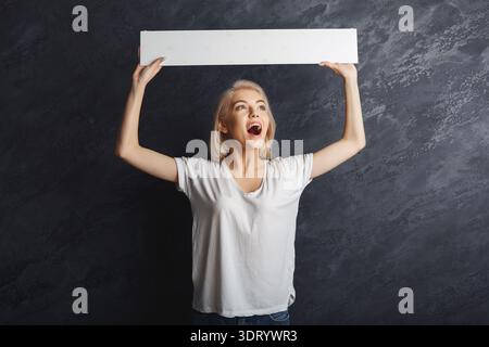 Creative Woman tiene una tavola vuota in un set collage con sfondo scuro Foto Stock