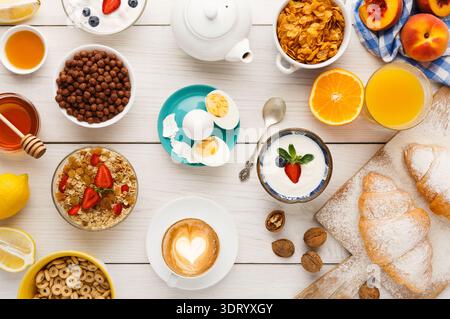 Collezione di pasti mattutini con vari cibi e bevande su un tavolo di legno Foto Stock