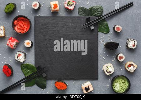 Delizioso allestimento di sushi con ardesia bianca per menu o presentazione su un tavolo Foto Stock
