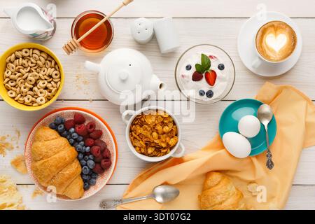 Colazione collage con croissant, frutta e yogurt su un tavolo di legno Foto Stock