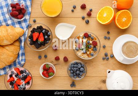 Raccolta di cibi da colazione disposti in un collage su un tavolo di legno con frutta fresca Foto Stock