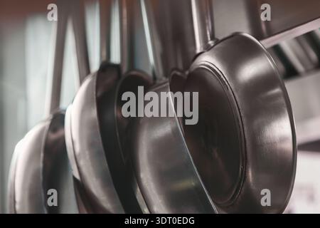 Collezione di padelle in metallo disposte per l'uso in un ambiente di cucina affollato Foto Stock