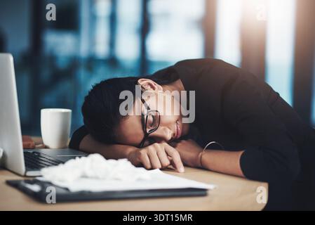 Stanco, donna e dormire al portatile in ufficio per bassa energia, influenza affaticamento o sovraccarico di scadenza. Tecnico, persona esausta o pisolino alla scrivania per malattia Foto Stock