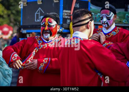Gli artisti d'opera Bangju con vivido trucco facciale adattano i loro costumi rossi dietro le quinte preparandosi per l'opera Justice Bao. Bangju Opera è un'opera tradizionale popolare nel nord dell'Anhui, nel nord del Jiangsu, nell'Henan orientale e in altre aree lungo il fiume Huaihe. Justice Bao è un classico pezzo Bangju su Bao Zheng, un funzionario della dinastia Song del Nord che sostiene la giustizia e punisce il male. Durante la festa di primavera, varie regioni ospitano una vasta gamma di attività culturali tradizionali per celebrare il Capodanno cinese. Foto Stock