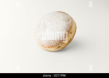 Una ciambella appena sfornata cosparsa di zucchero in polvere con ombre morbide su sfondo chiaro. Dolce primo piano di ciambelle. Ciambella berlinese. Carta di pasticceria in tren Foto Stock