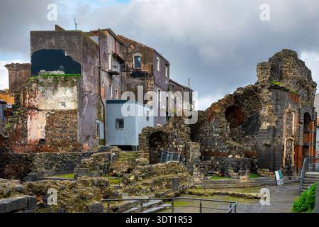 Rovine romane di Odeon a Catania, Sicilia, Italia con archi in pietra sotto il cielo nuvoloso. Foto Stock