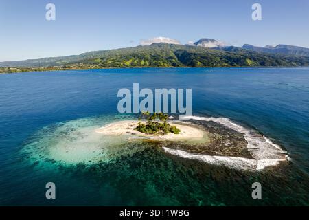Scopri una vista aerea mozzafiato di una piccola e lussureggiante isola tropicale circondata da acque turchesi nella Polinesia francese. Scopri la bellezza incontaminata Foto Stock