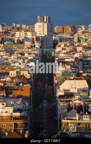 Una splendida vista aerea di Madrid che mostra un vasto paesaggio urbano con edifici densamente affollati. Sullo sfondo, montagne maestose con grazia Foto Stock