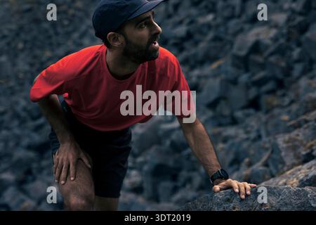 Atleta maschile su un terreno roccioso spettacolare Foto Stock