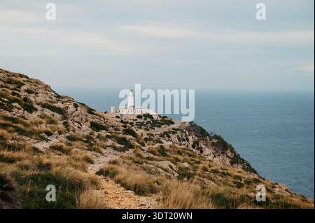 Vista distante del faro di Formentor sulle scogliere rocciose, Cap de Formentor Foto Stock