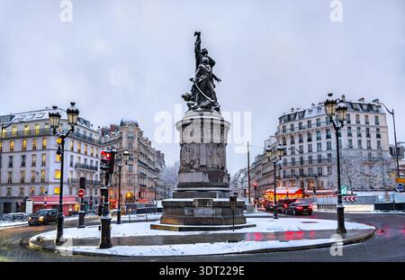 Vista innevata del Monumento al Maresciallo Moncey in Place de Clichy a Parigi, Francia. Presenta la statua in bronzo, gli edifici classici e le strade innevate in un giorno d'inverno Foto Stock