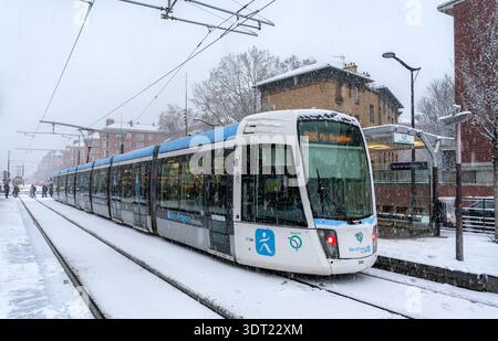 Parigi, Francia - 5 gennaio 2026: Forti tempeste di neve causano disagi ai trasporti alla fermata porte de Saint-Ouen del tram. Tram linea T3b sulla piattaforma durante il caos invernale Foto Stock