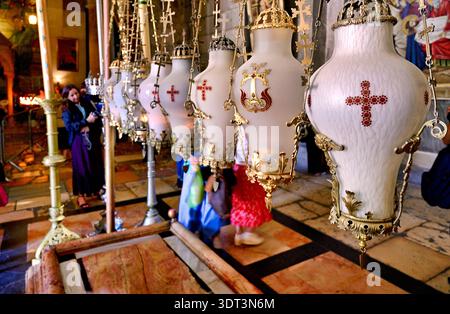 La gente cammina attraverso la chiesa del Santo Sepolcro. Durante la loro visita visitano manufatti religiosi e prendono parte a rituali. Foto Stock