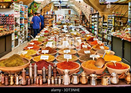 Nella città vecchia di Gerusalemme, i venditori espongono varie spezie in ciotole. I clienti esplorano ed esplorano la vivace selezione di prodotti. Foto Stock